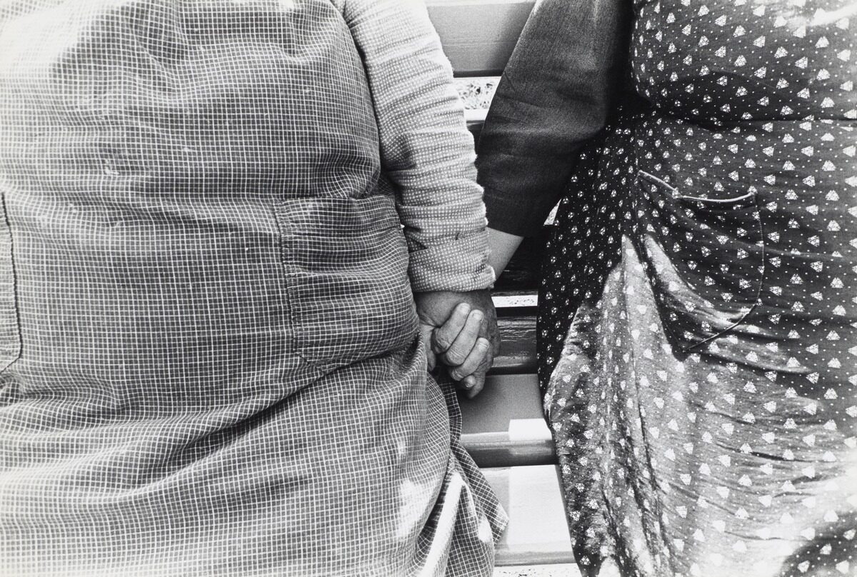 Black-and-white photograph of two presumably elderly women holding hands. The photograph was taken at the retirement and nursing home in Utzigen in 1971/1972.