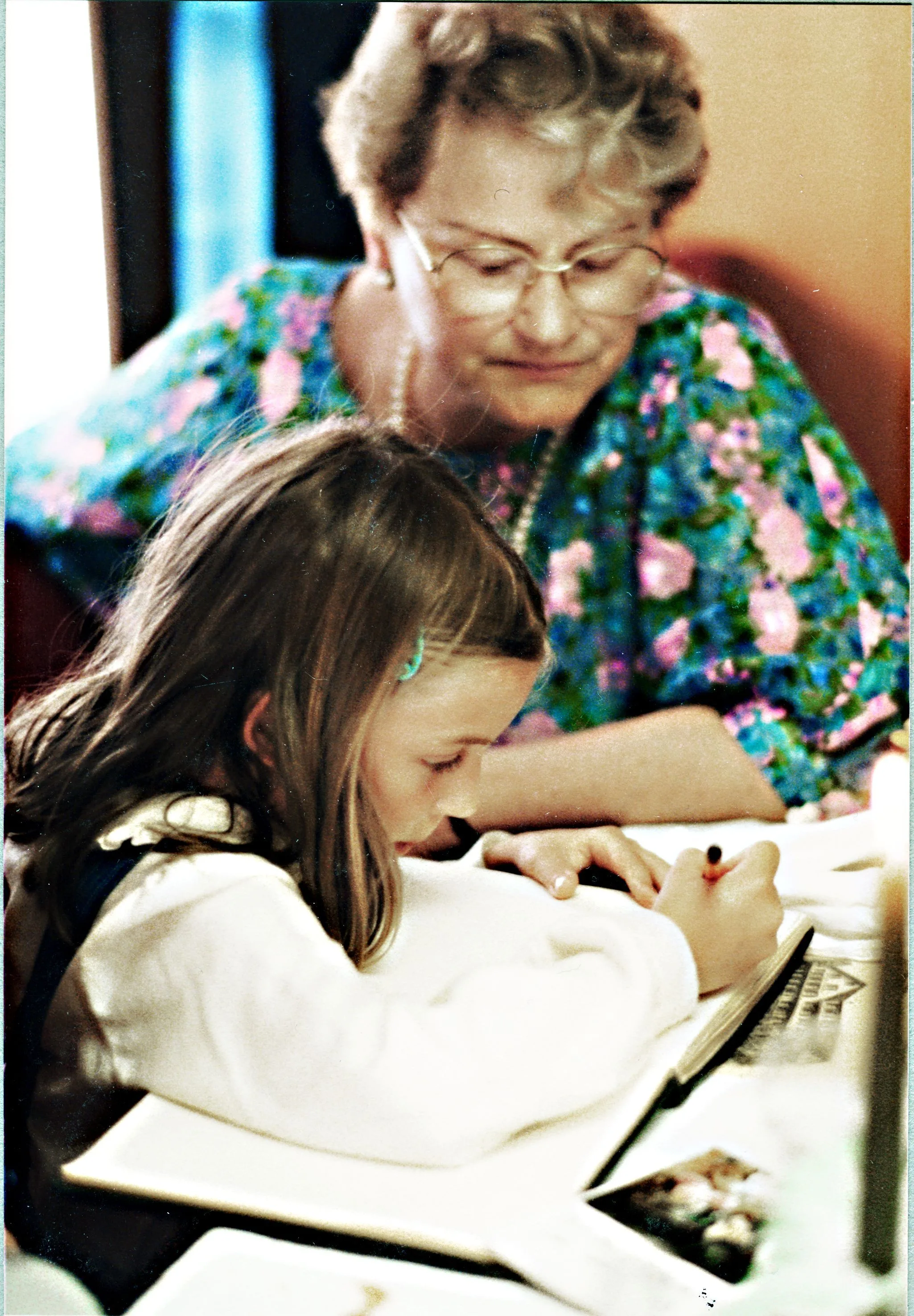 Colour photograph of an elderly woman watching a young girl write. The woman is child psychiatrist Dr Marie Berta Meierhofer (1909–1998).